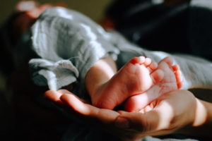 Newborn baby feet in hand